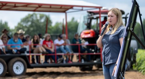 woman talking into a microphone at an agricultural field day