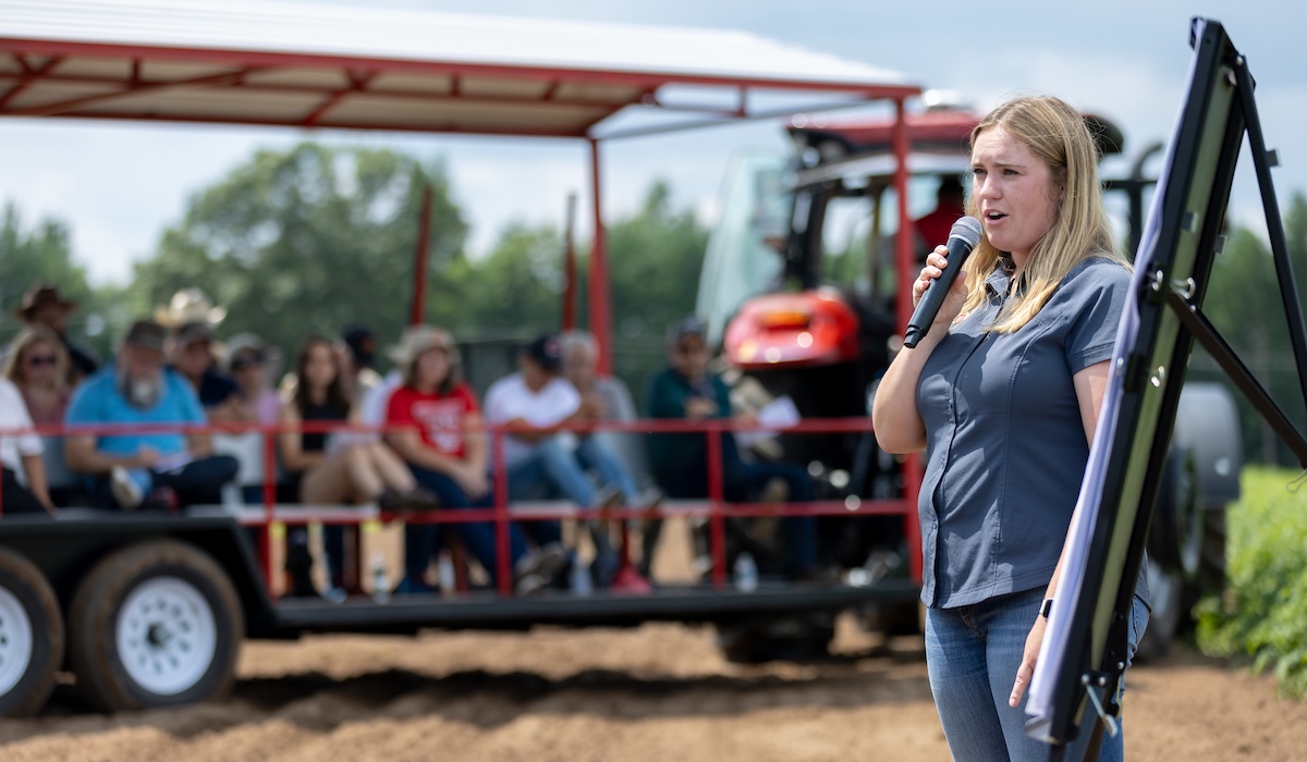 woman talking into a microphone at an agricultural field day